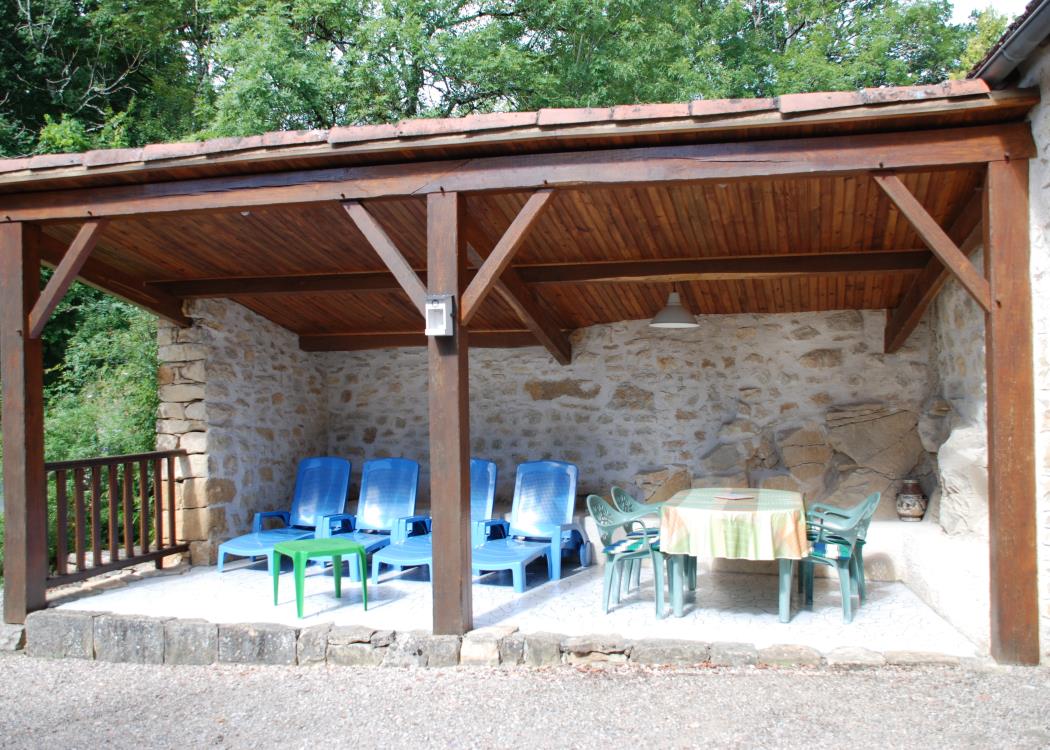 Terrasse couverte avec bains de soleil, table et chaises